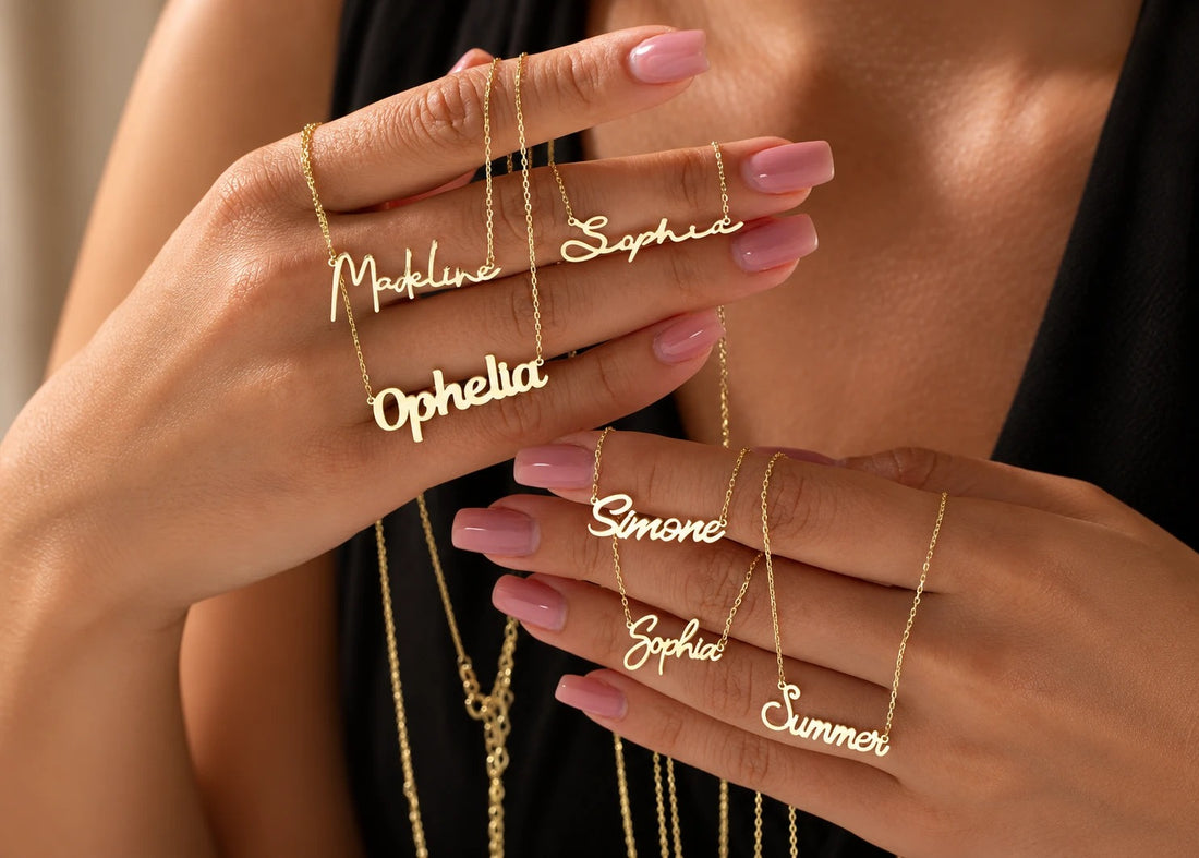 Hands holding several solid gold name necklaces in different script fonts